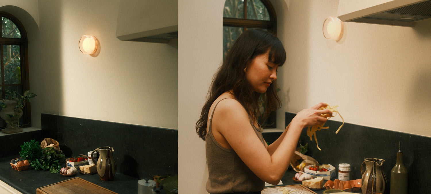woman cooking pasta in spanish-style home with two Firth Wall Lights mounted to the wall