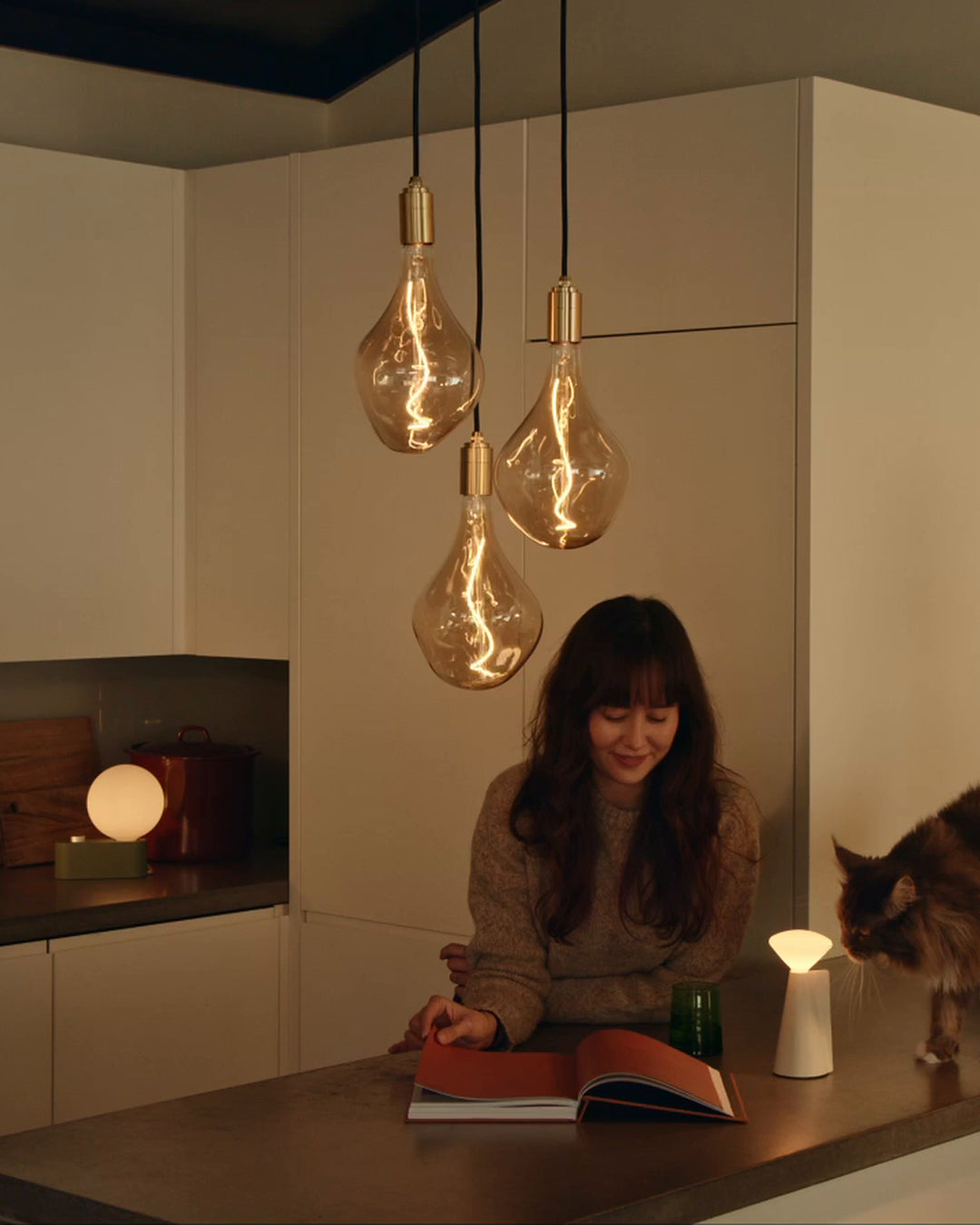 triple pendant, alumina table lamp, and mantle portable lamp in a dining room